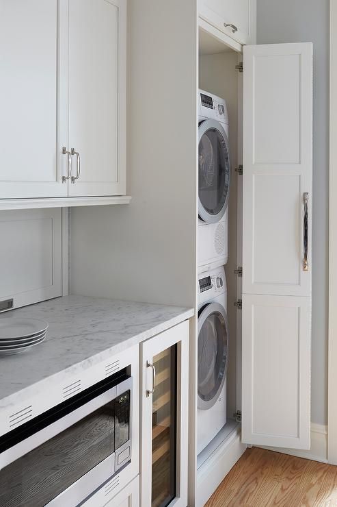 a neutral laundry with shaker style kitchen cabinets, neutral stone countertops and much storage space is lovely