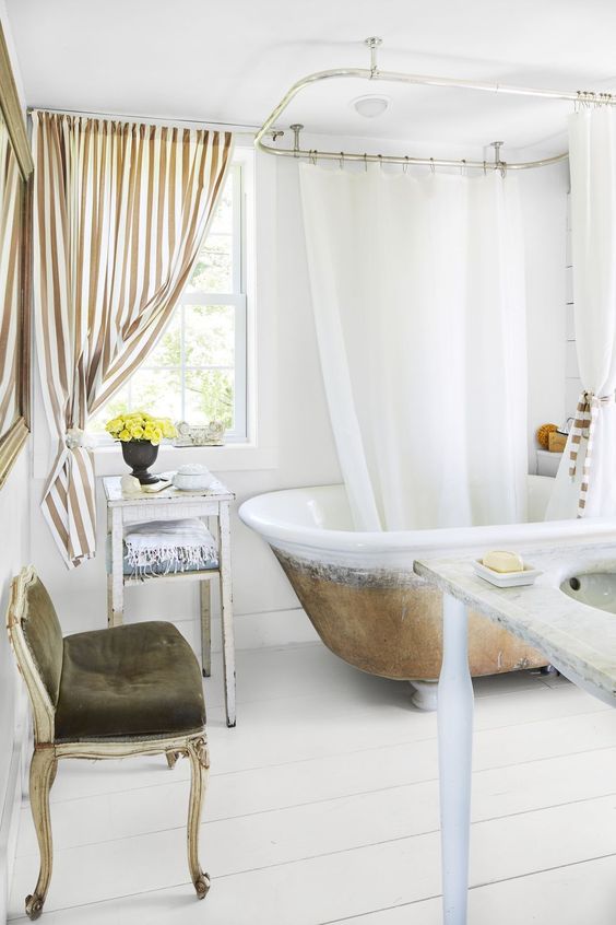a fancy bathroom with white planked walls and a floor, a vintage bathtub, vintage and refined furniture, a striped curtain looks wow