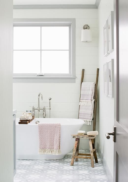 a modern country bathroom with white planked walls, a grey tile floor, white appliances, rough wooden accessories is cool