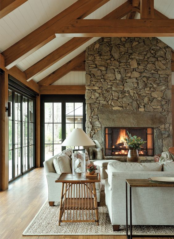 a cozy living room with a large stone fireplace
