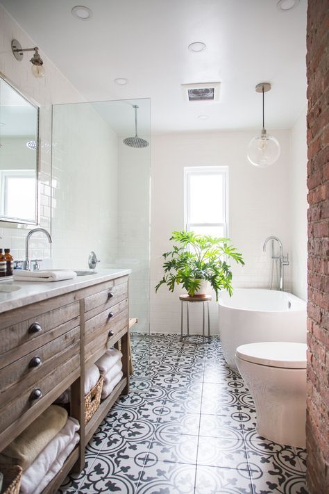 a modern rustic bathroom with white walls and a mosaic tile floor, a rough wooden vanity and white appliances plus a potted plant