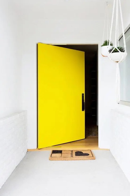 a white entrance with a concrete floor and an oversized yellow square front door are amazing to highlight the exterior of your home