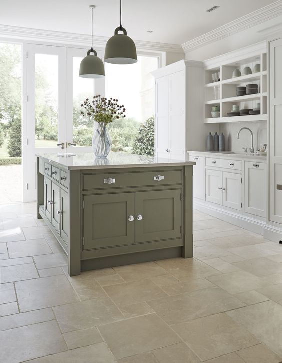 an elegant dove grey and green modern country kitchen with green pendant lamps and a stone floor is a chic and welcoming space