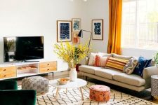 06 a bright mid-century modern living room with a comfy sofa, a green chair, a TV unit, printed textiles and a bright gallery wall