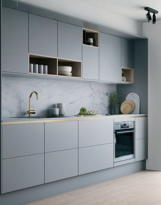 a minimalist grey kitchen with sleek cabinets with open storage compartments, a white marble backsplash and gold touches for more elegance