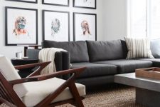 08 an elegant mid-century modern living room with a grey sofa, a concrete table, a white chair, a bright portrait gallery wall