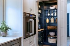 29 a small pantry integrated right into the kitchen and matching it in style but done in a contrasting navy color