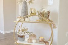 31 a lovely rounded gold bar cart on casters styled for the fall, with pumpkins, pampas grass, metallic leaves and wooden beads