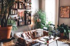 35 a lovely boho living room done with lots of potted greenery and succulents, with strign lights over the space, a fiery red faceted side table