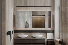 a beautiful bathroom clad with wood-imitating tiles, an oval tub and matching sinks, a large mirror and built-in lights