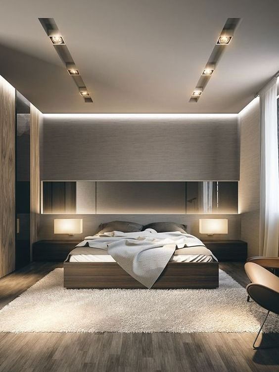 a beautiful contemporary bedroom done in elegant neutral tones, with several layers of light, a bed and matching sleek nightstands plus a long mirror