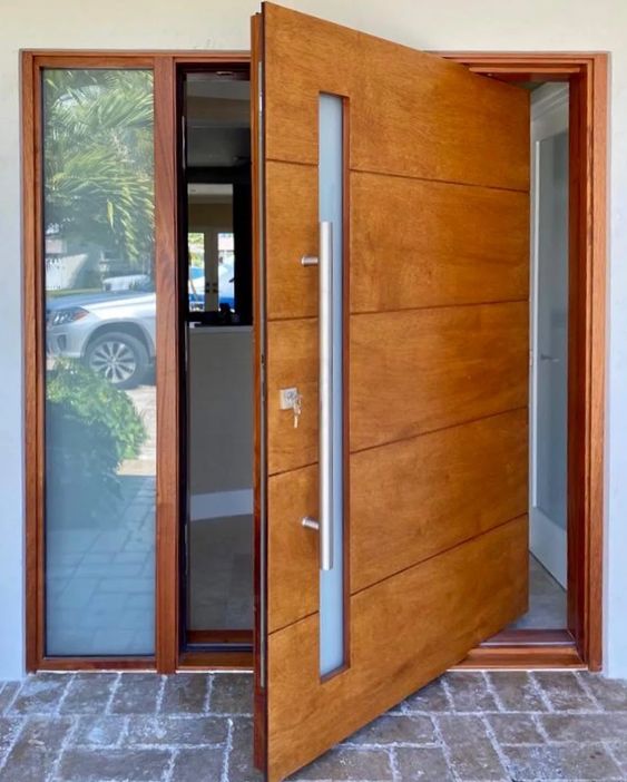 a beautiful modern rich stained pivot wooden door with a frosted glass insert is a very cool idea for a modern entrance