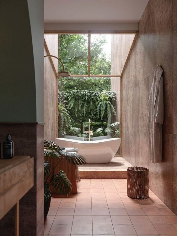 a biophilic bathroom clad with terracotta tiles, with a wooden vanity and a tree stump and a living wall is a gorgeous space