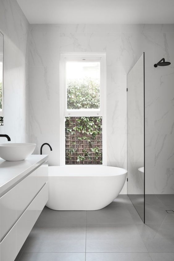 a contemporary to minimalist bathroom with a shower space enclosed in glass, a floating vanity, a tub and black fixtures