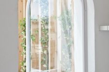 a cool white arched metal frame and glass pivot door that leads to the garden is a gorgeous idea to rock