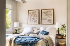 a farmhouse light-filled bedroom with an upholstered white bed and open nightstands, baskets, potted greenery and botanical artworks