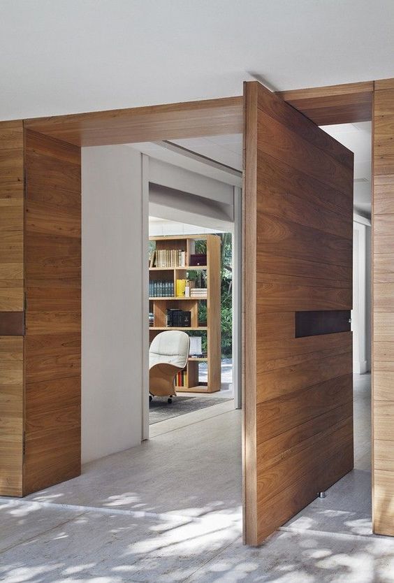 a light stained wood pivot door with a handle integrated into a niche is a lovely idea for a beautiful modern space
