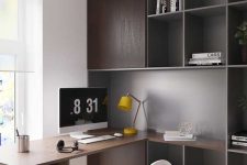 a simple contemporary home office with dark stained storage cabinets and a built-in desk plus open storage units, a white chair