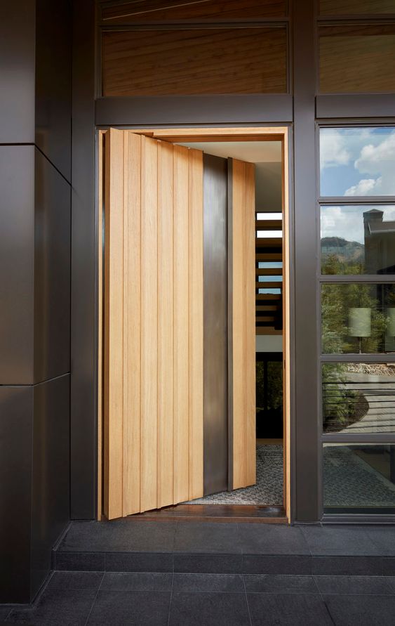 a stylish light-stained and metal pivot entrance door is a lovely solution for a modern home and adds chic to the porch