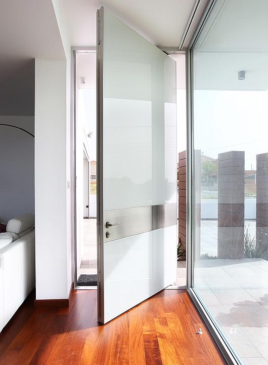 a unique frosted glass and metal pivot door is an ultra-modern and fresh solution is a bold statement for any space