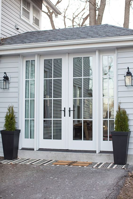 elegant white French doors with black handles are a very stylish and cool solution for any entrance, they look amazing and can be styled in many ways