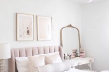 04 a beautiful neutral bedroom with a blush bed, neutral bedding, a small vanity and a mirror, a white nightstand, a mini gallery wall