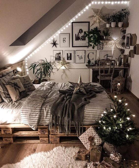 a welcoming attic bedroom with LED lights, a pallet bed, a desk and vanity space and a gallery wall plus potted greenery