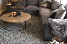 20 a grey living room with a large taupe sectional, a round coffee table, a floor lamp, various pillows and a taupe rug
