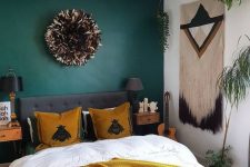 24 a pretty boho bedroom with a verdant green accent wall, a grey upholstered bed, a mustard blanket and pillows, matching floating nightstands, black lamps