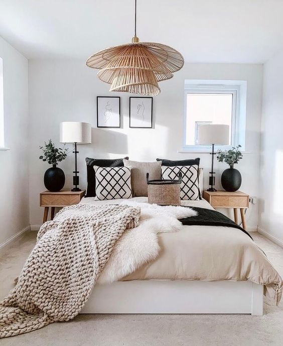 printed pillows, matching black vases and a creative tiered pendant lamp make this bedroom look unusual, stylish and bold