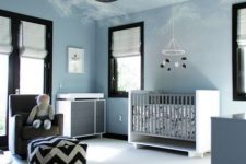 a contemporary sky blue nursery with a neutral crib and changing table, a grey chair and a printed ottoman plus a yarn ball lamp