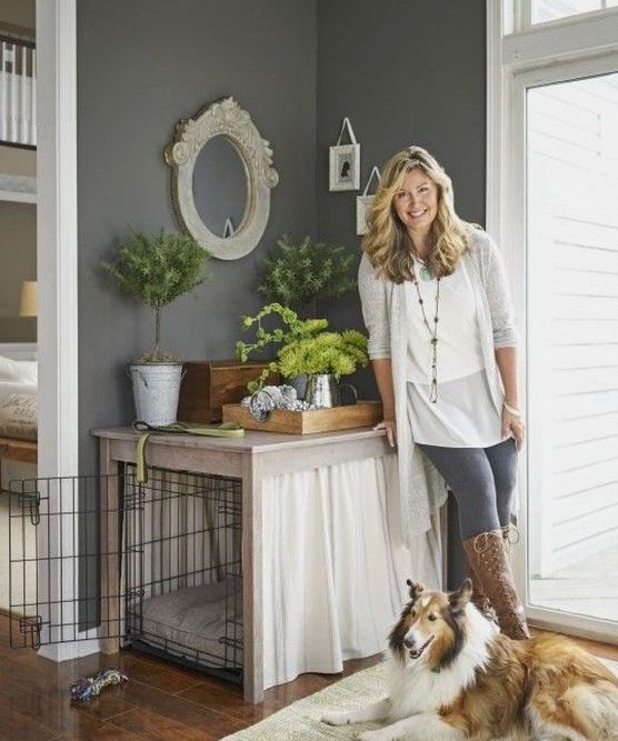 a cozy and private dog crate with curtains doubles as a plant stand and matches the vintage farmhouse style of the space