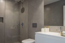 a minimalist taupe bathroom with concrete walls, floor and a shower space, a white floating vanity, a large mirror and white appliances
