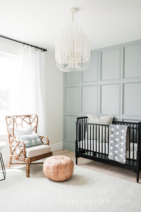 a neutral nursery with a styish panelled wall