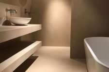 an ultra-minimalist taupe bathroom with matte walls and a floor, open shelves, an oval taupe tub and a white bowl sink is amazing