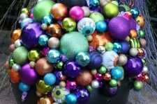 13 a Halloween decoration of a black cauldron and lots of colorful Christmas ornaments and eyeballs is bold and lovely