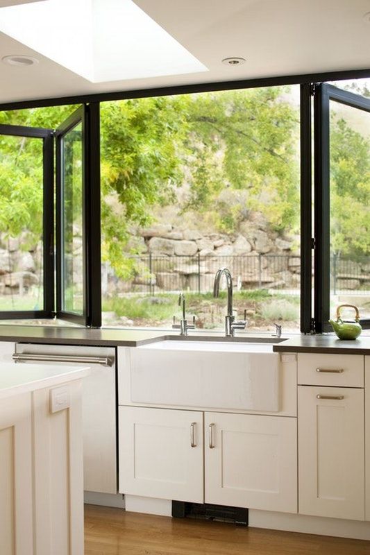a neutral farmhouse kitchen with dark countertops, a black folding window and cool and fresh views is amazing