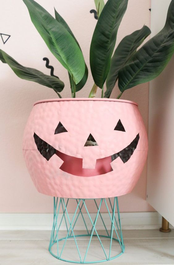 a pink jack-o-lantern cauldron is a lovely cover for a planter or a bowl to serve something and it will do for many Halloween parties