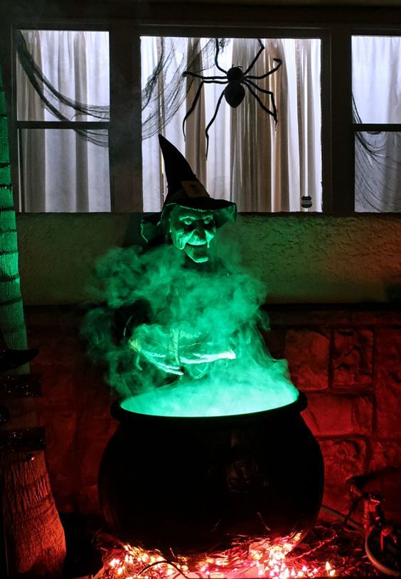 a witch cauldron prop wih additional green lights and some lights under it is a cool solution for outdoor Halloween decor