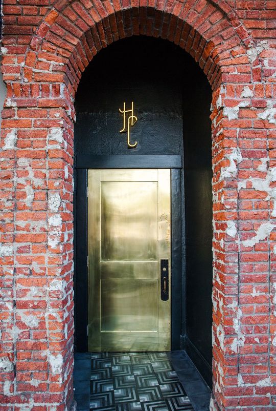 a brass finish metal front door plus a black entry make a bold and contrasting statement and make the entrace very dramatic