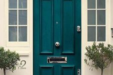 a classic front door with French sidelights painted teal looks bold and unusual and makes a statement with its color at once