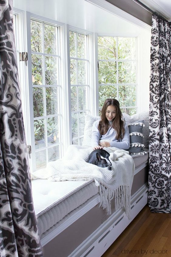 a cool bow window with a windowsill daybed with a large mattress and some pillows is a lovely space to spend time and maybe read books