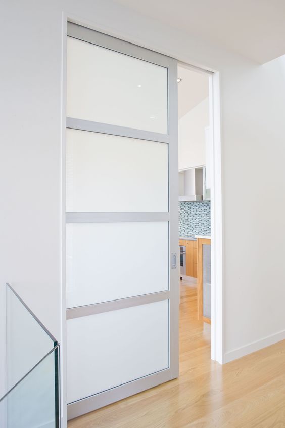 a forsted glass and metal pocket door is a cool way to save some space and still divide the spaces in a stylish way
