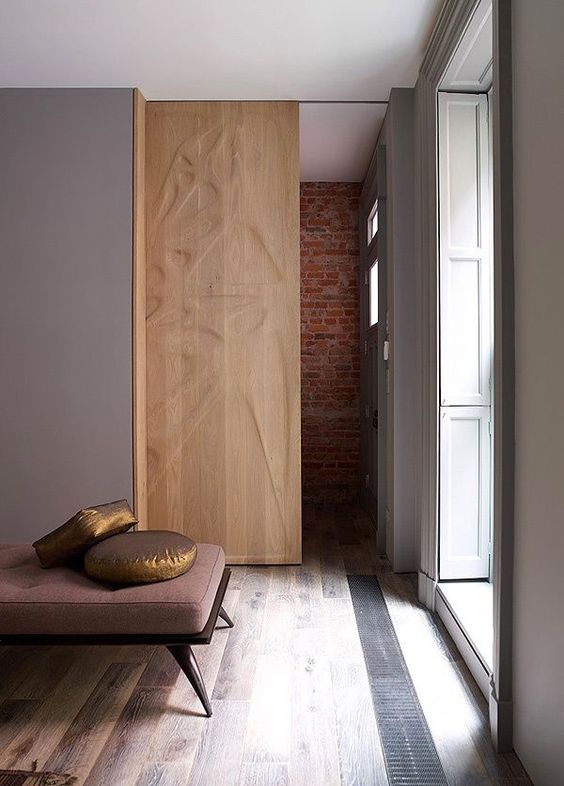 a gorgeous wooden pocket door with a pattern is a beautiful decor feature that separates the space in a cool way