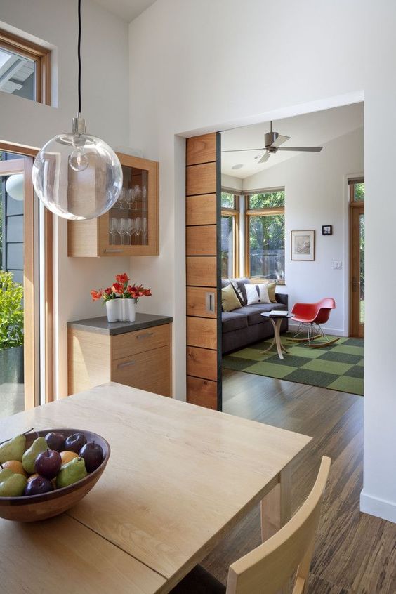 a light stained pocket door leading to a dining room is a cool addition to a mid-century modern interior and it adds a warm touch