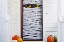 a mummy-shaped front door, a couple of pumpkins and a cat skeleton are all you need to make your front porch look Halloween-like