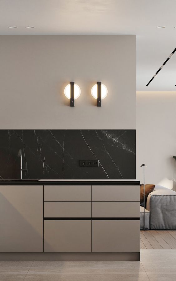 a refined minimalist greige kitchen with sleek cabinets, a black marble backsplash and neutral countertops plus matte black fixtures
