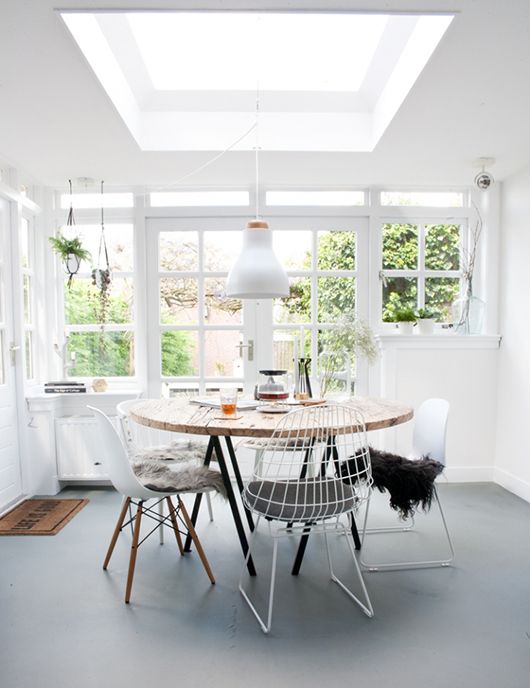 a simple square skylight gives much light to this dining room together with the glazed wall and they make the space amazing