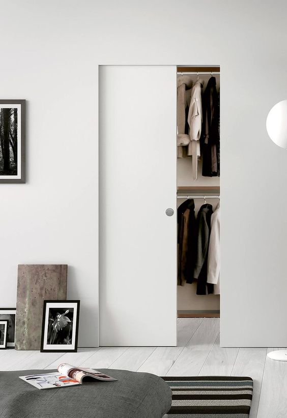 a sleek and small pocket door with a knob is a cool idea to separate the bedroom and the closet with style and without wasting room