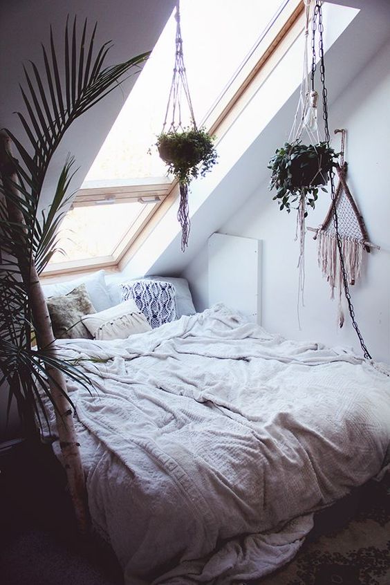 a small attic bedroom with a skylight as the only window looks very cozy and wlecoming